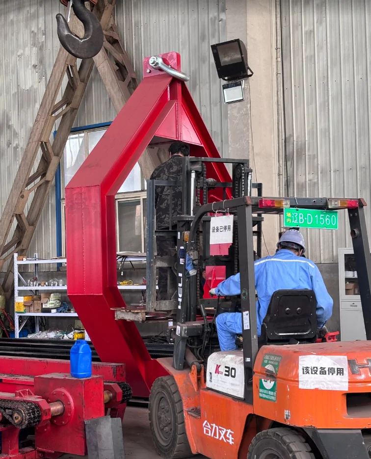 Workers using a forklift to position the red lifting frame on a Qingwei tube bundle extractor